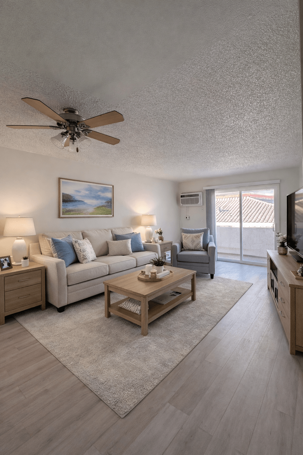 A living room with a couch, coffee table, and a ceiling fan.